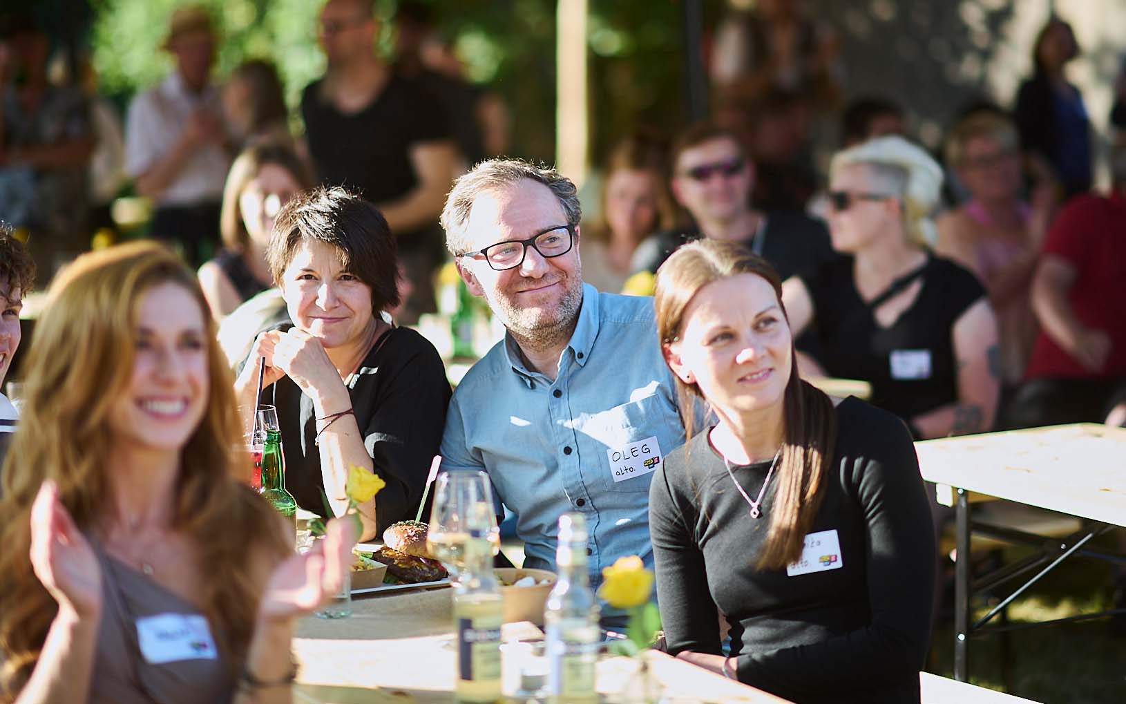 Grafikdesigner Oleg sitzt auf einer Bank bei der Jubiläumsfeier der Digitalagentur alto.