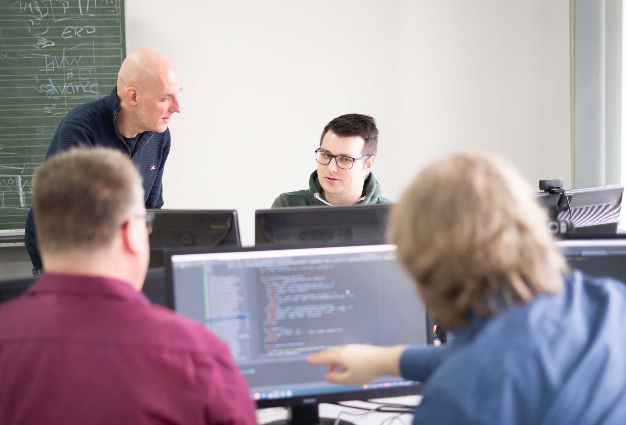 Webdesign Agentur bei der gemeinsamen Arbeit von Entwicklern an Code und digitalen Lösungen.